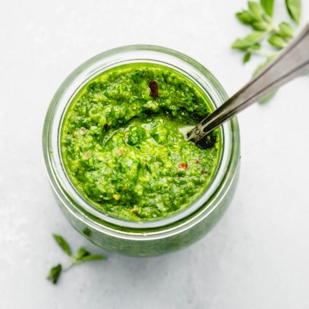 Chimichurri sauce in small jar with spoon.