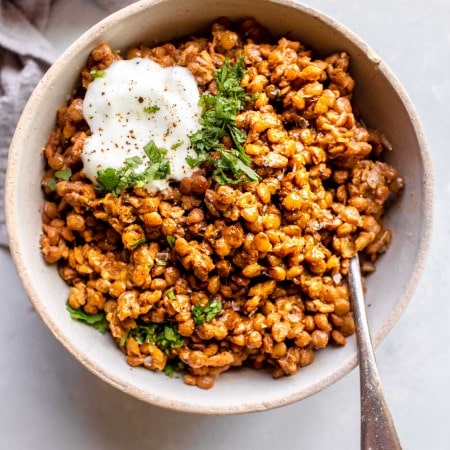 Instant pot lentils in bowl topped with yogurt and cilantro