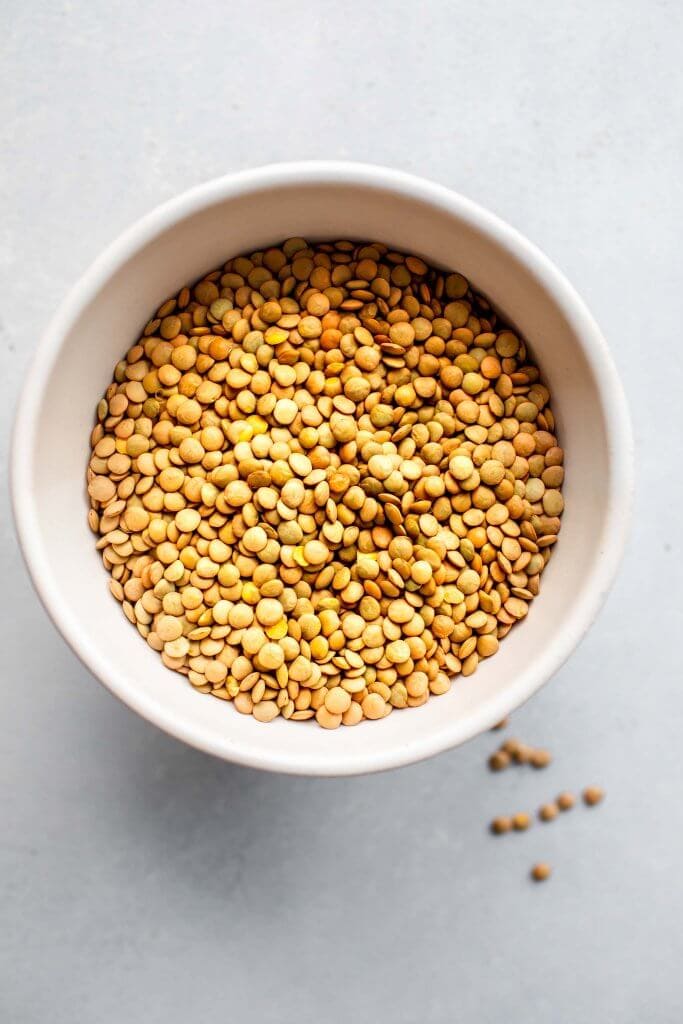 Uncooked lentils in white bowl