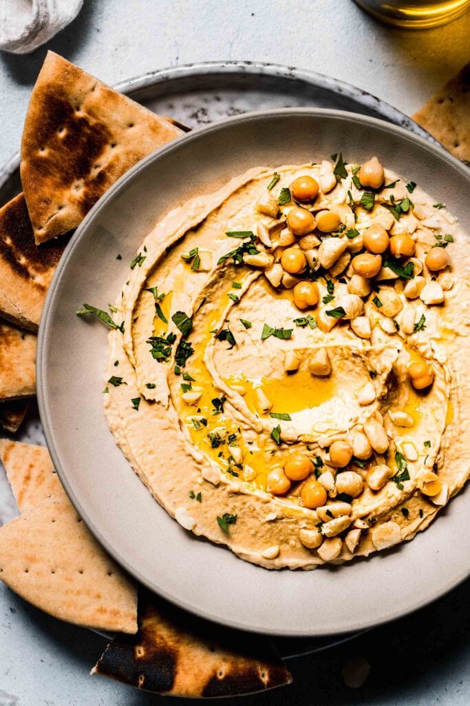 Macadamia nut hummus in bowl drizzled with olive oil. 
