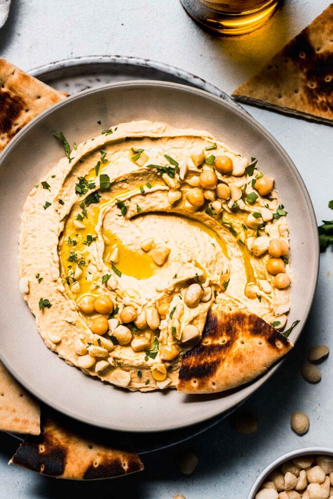 Piece of pita dipped into hummus.