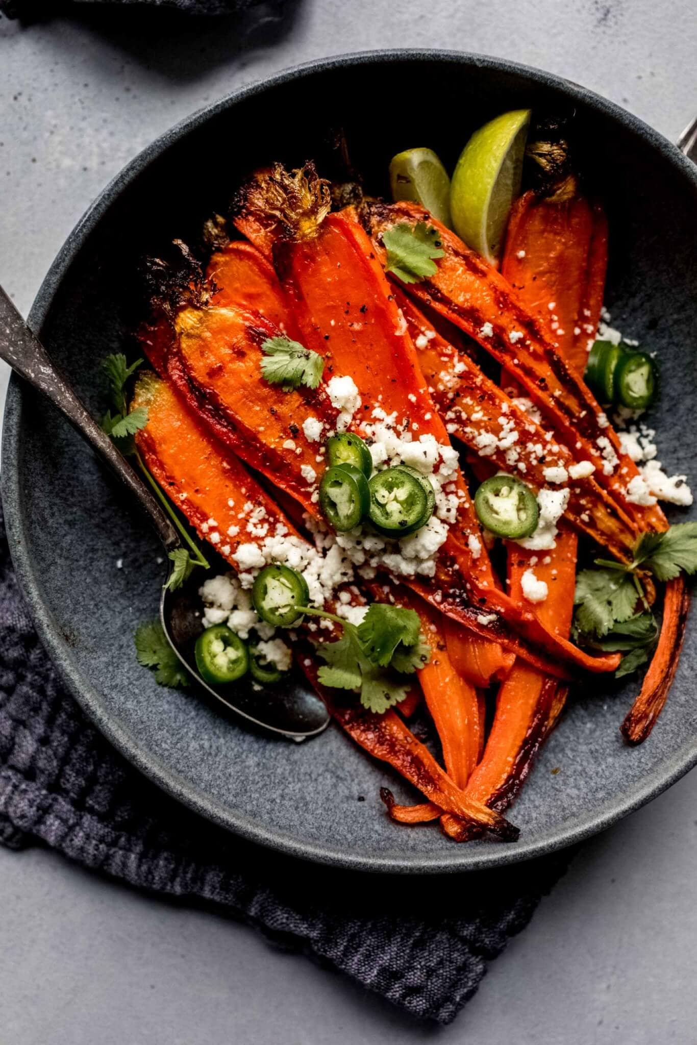 Roasted carrots in bowl with spoon.