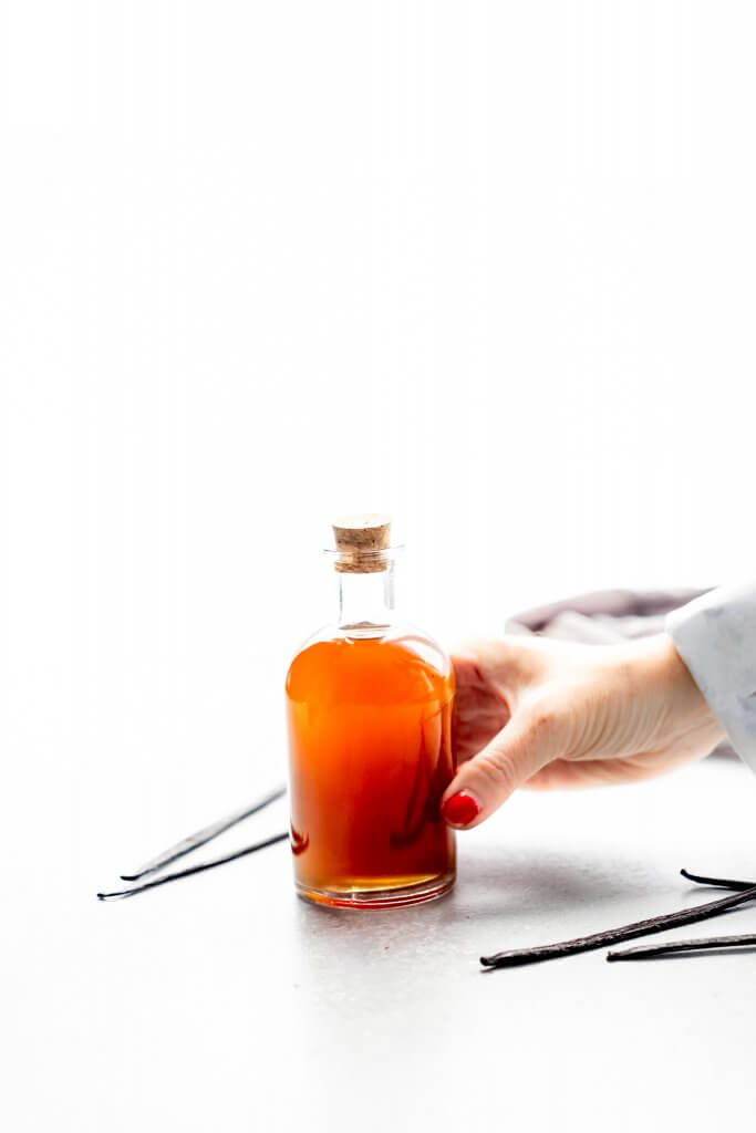 Hand holding bottle of sous vide vanilla extract.