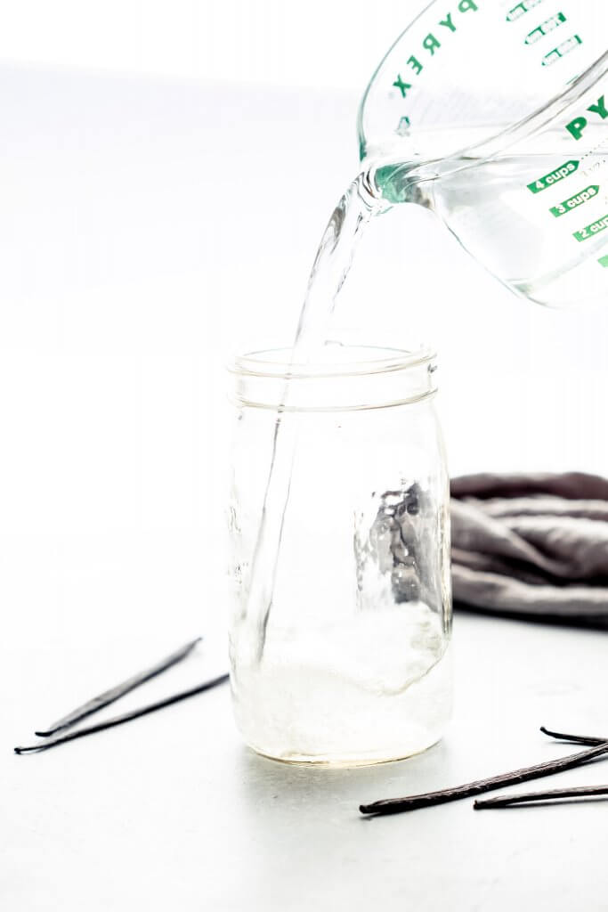 VODKA BEING POURED INTO MASON JAR