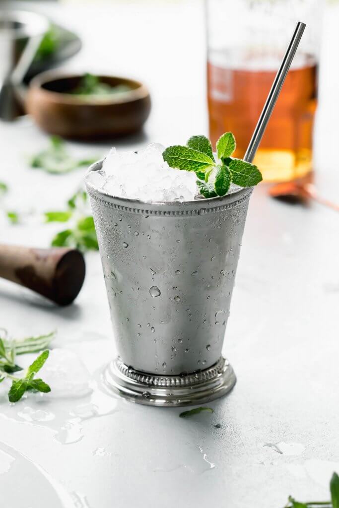 Side view of one mint julep in julep cup with sprig of mint