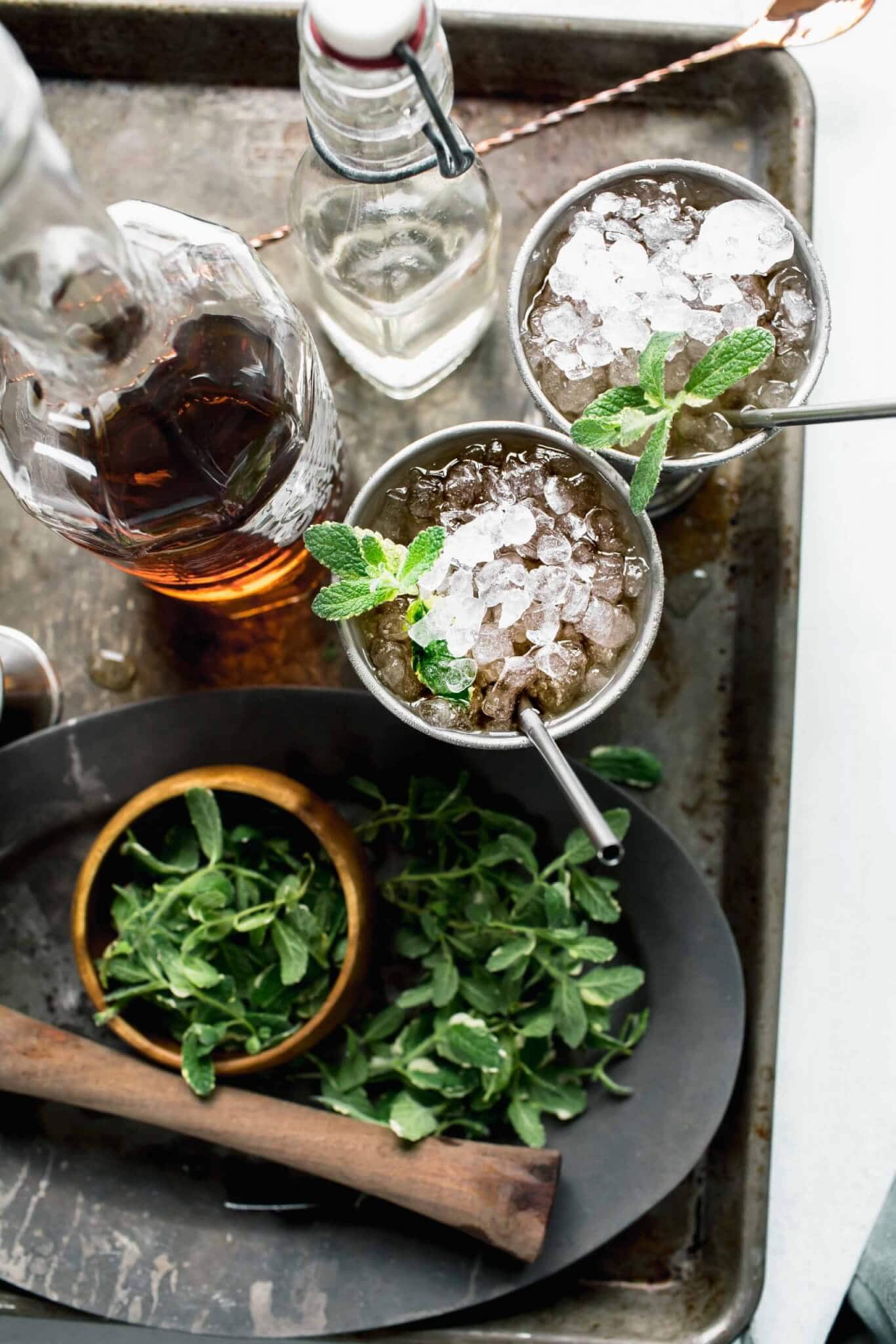 Two assembled mint juleps on serving tray