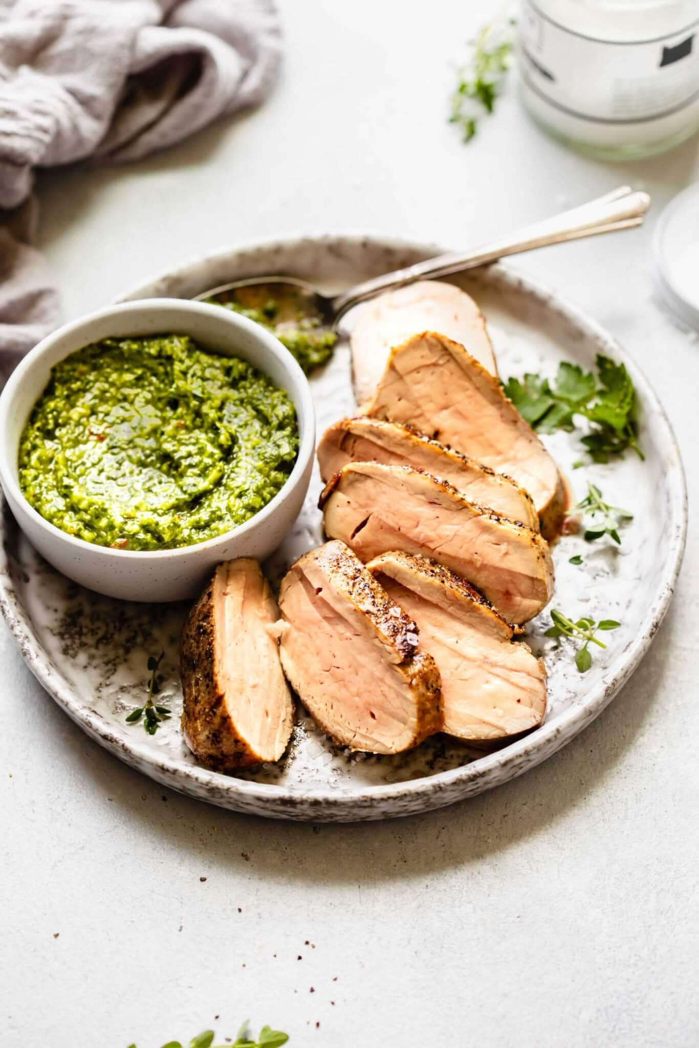 Side view of sliced pork tenderloin on grey plate