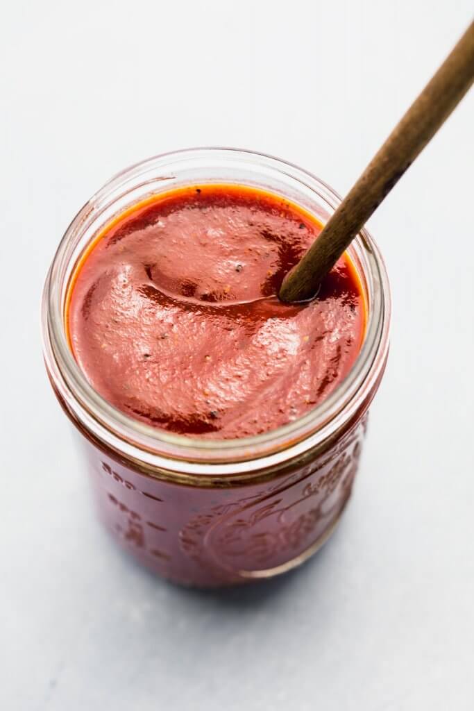 Side view of homemade bbq sauce in jar with spoon