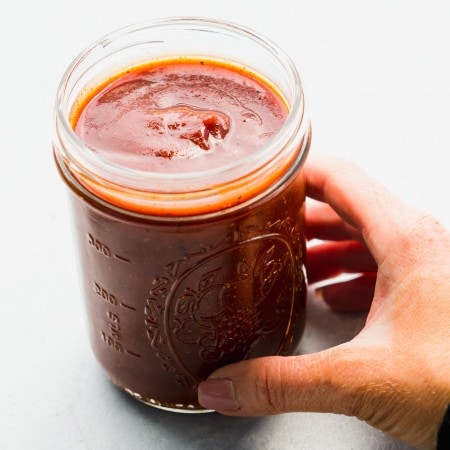 Hand holding jar of homemade bbq sauce