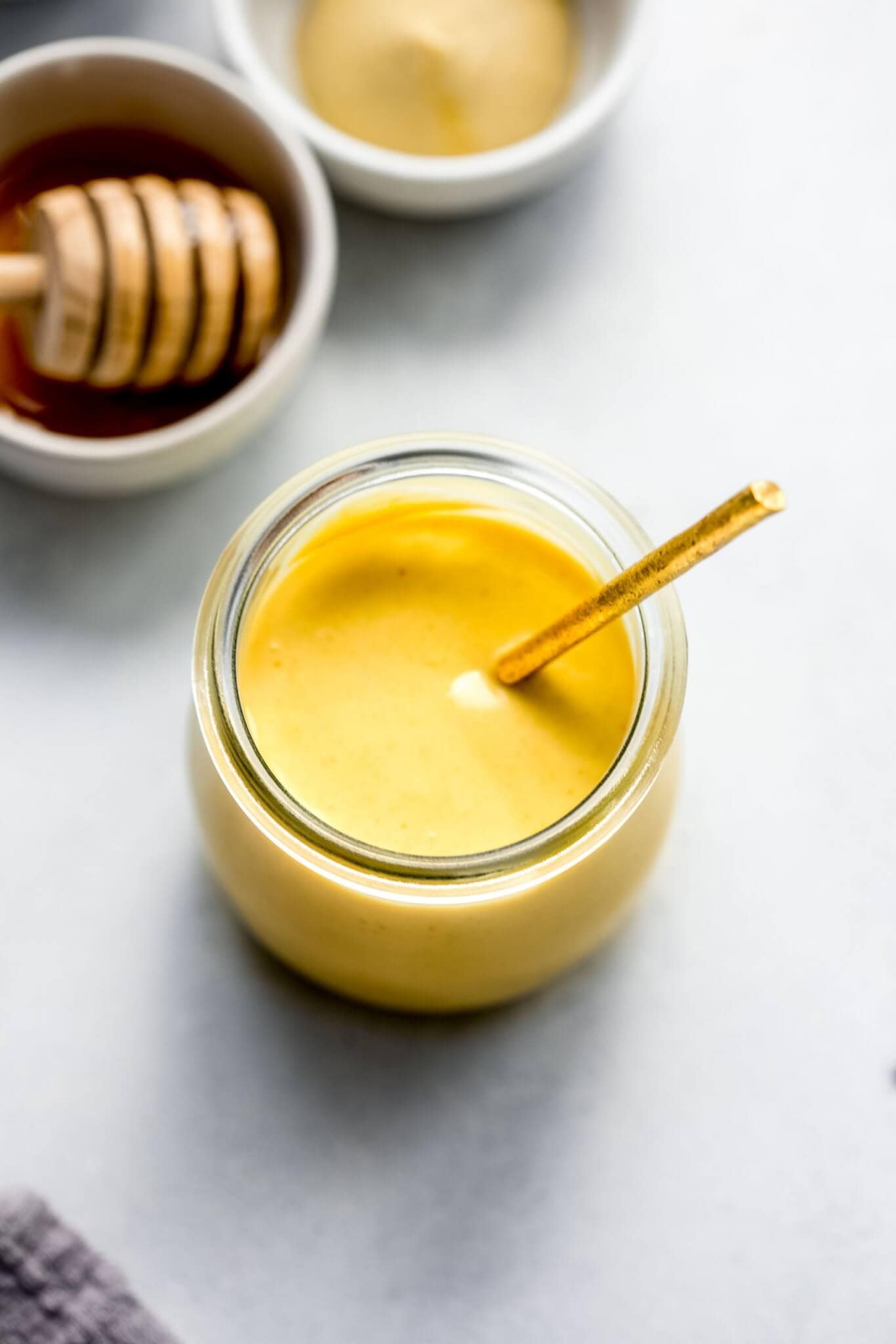 Overhead shot of honey mustard in glass jar with gold spoon
