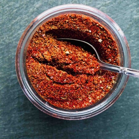 OVERHEAD SHOT OF TACO SEASONING IN GLASS CONTAINER WITH SPOON