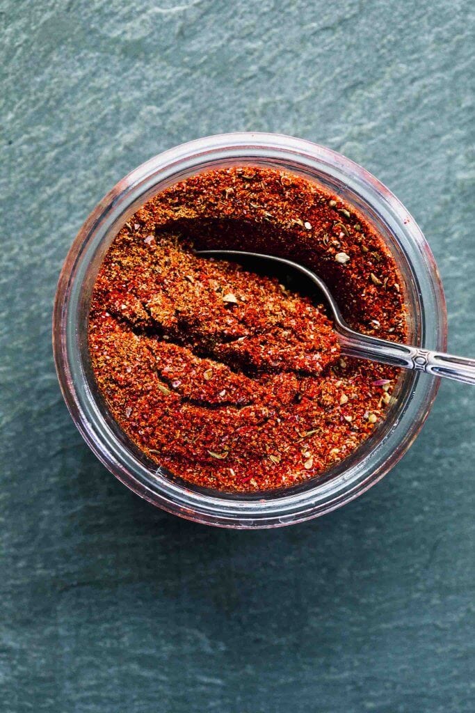 OVERHEAD SHOT OF TACO SEASONING IN GLASS CONTAINER WITH SPOON