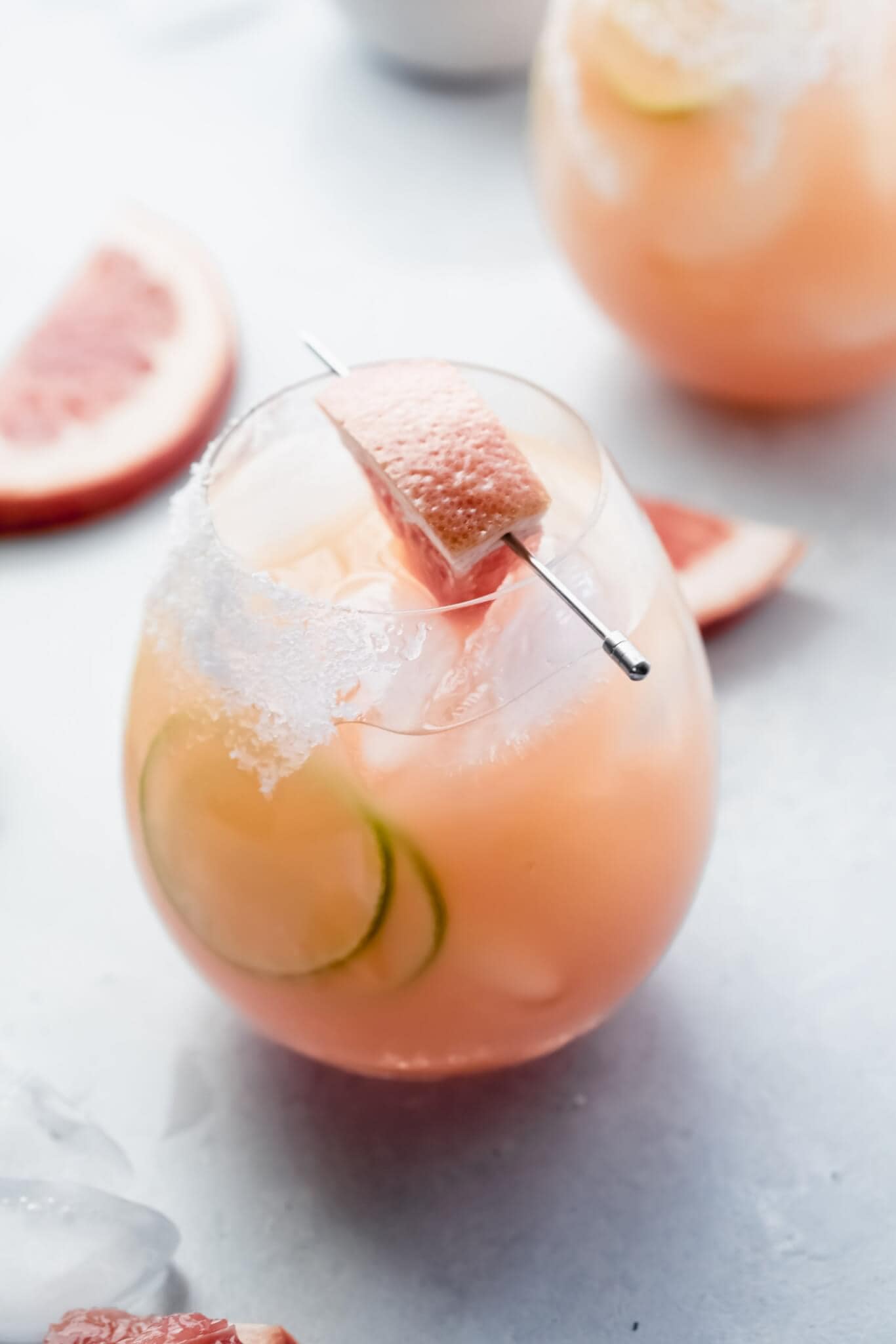 Side view of paloma cocktail garnished with grapefruit wedge.