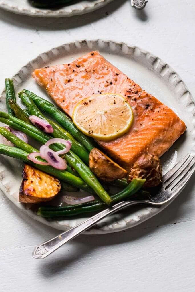 Baked salmon on plate with green beans.