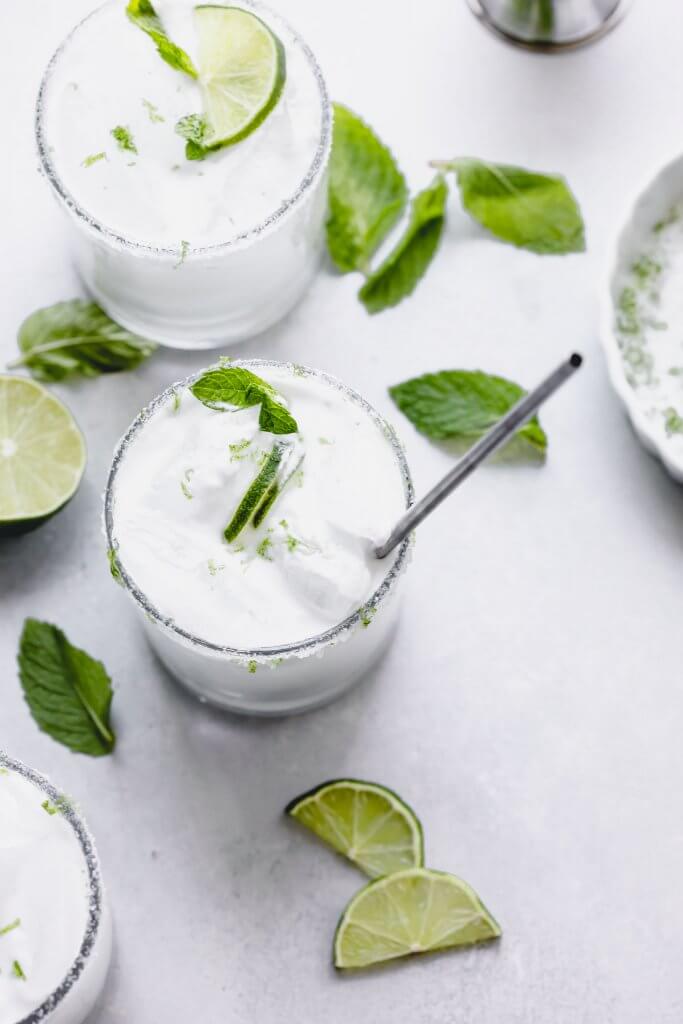 Three coconut mojitos in glasses with straws.