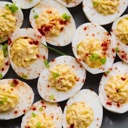 Deviled eggs on grey plate sprinkled with paprika.