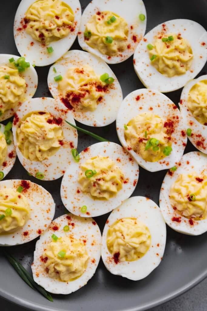 Deviled eggs on grey plate sprinkled with paprika.