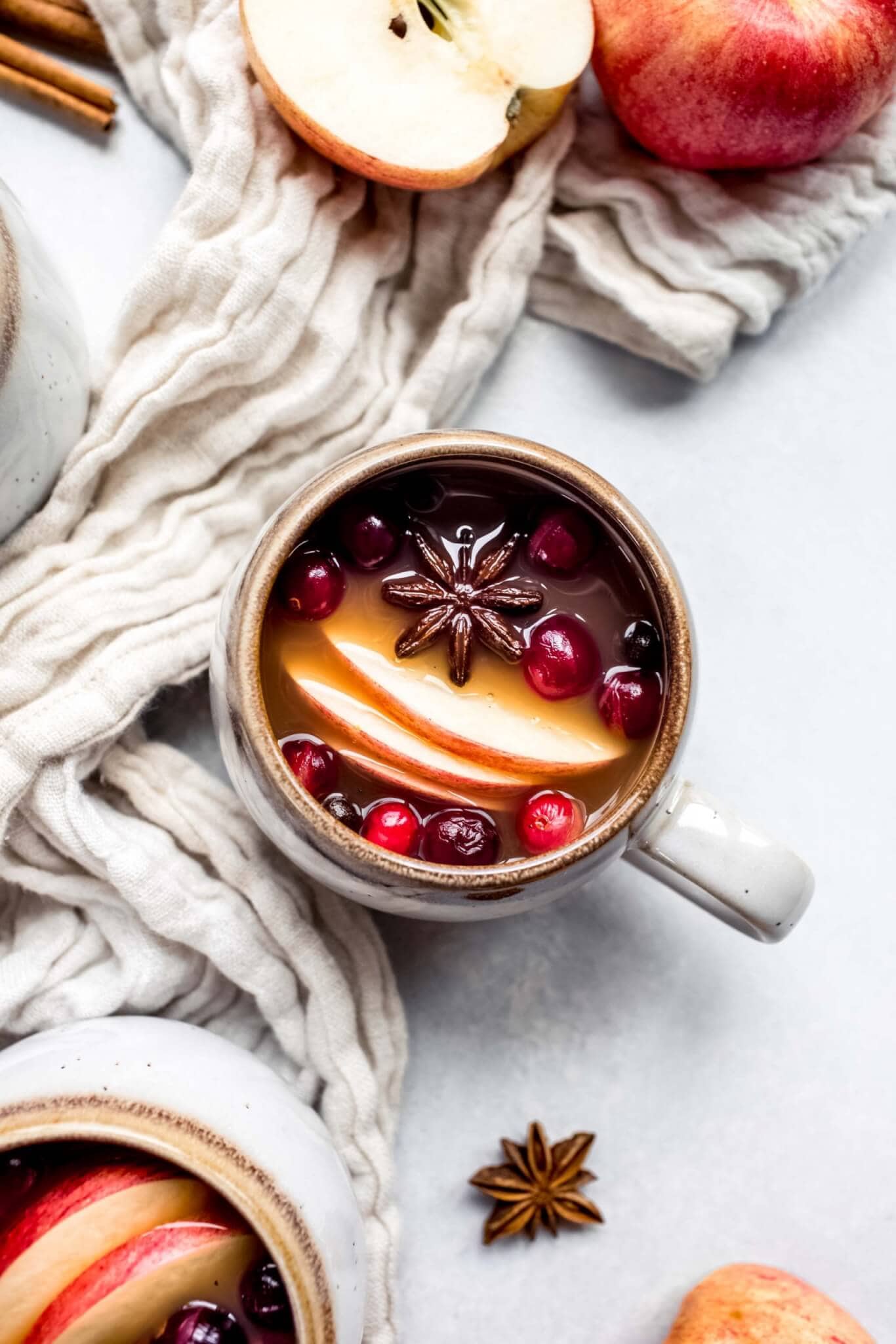 Overhead shot of mulled cider next to apple cut in half. 