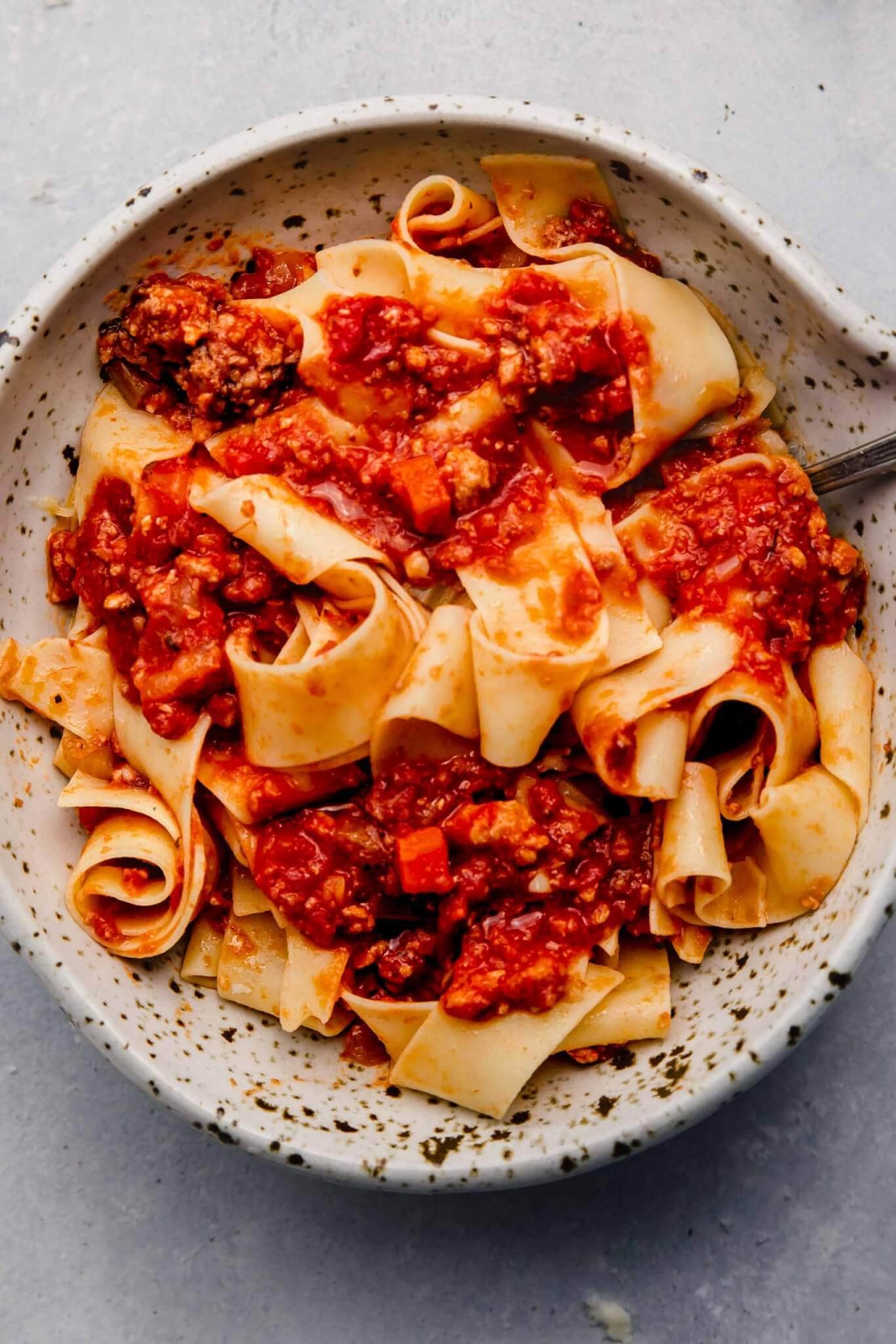 Overhead close up of bowl of pasta topped with slow cooker bolognese
