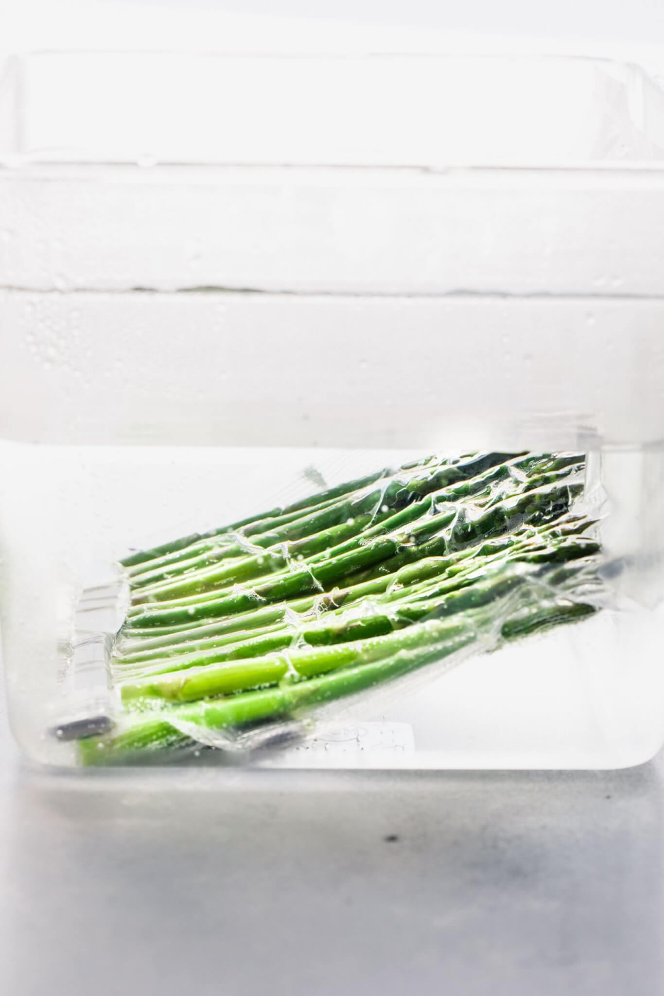 Asparagus floating in sous vide water bath