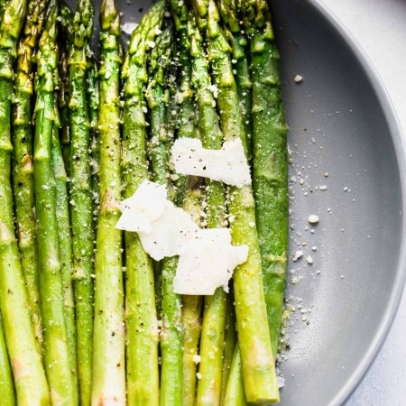 Spears of asparagus cooked sous vide topped with parmesan shavings.