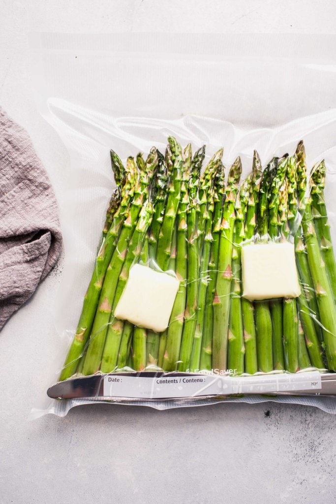 Asparagus sealed in bag with knives and butter pats. 