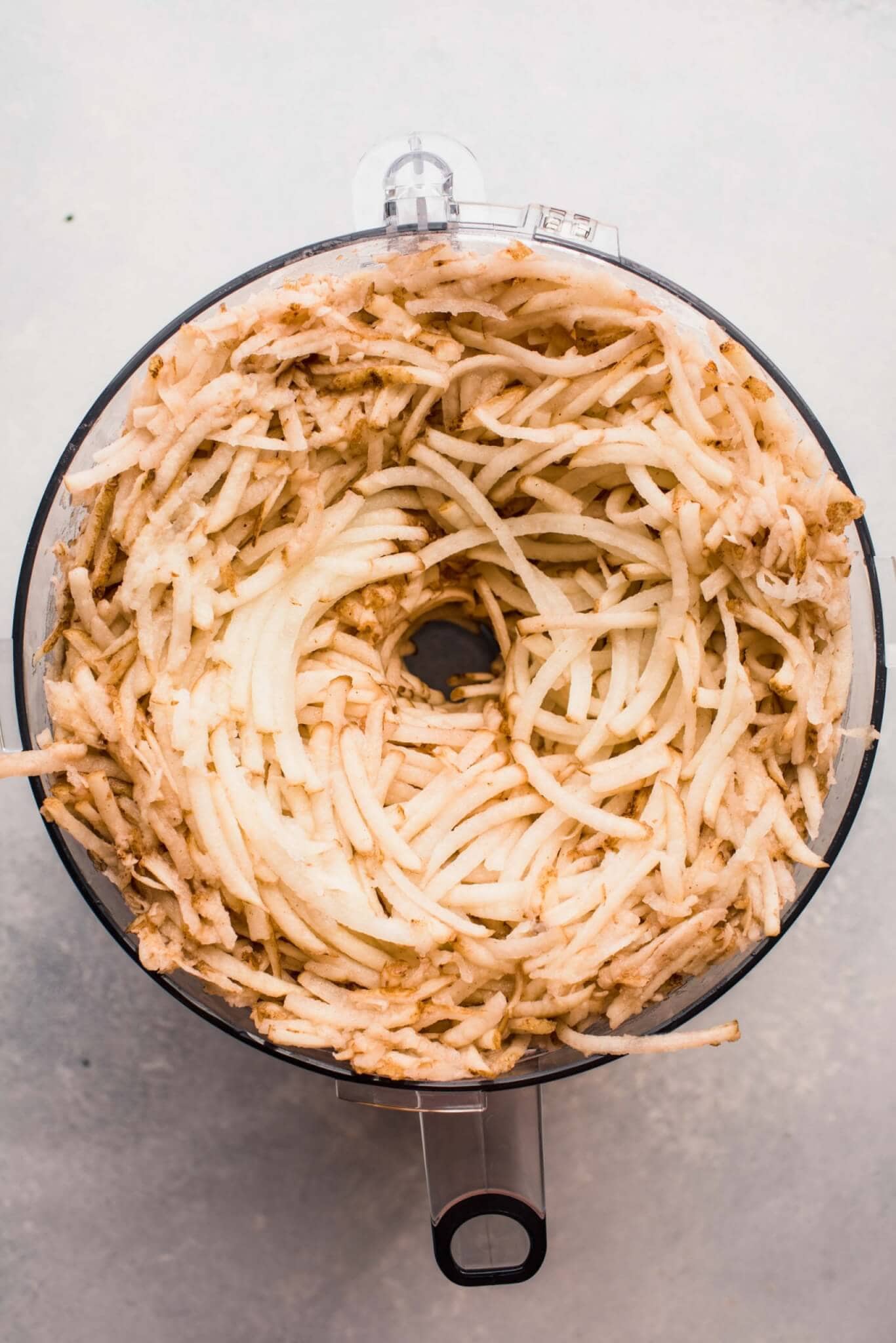 SHREDDED POTATOES IN FOOD PROCESSOR BOWL. 