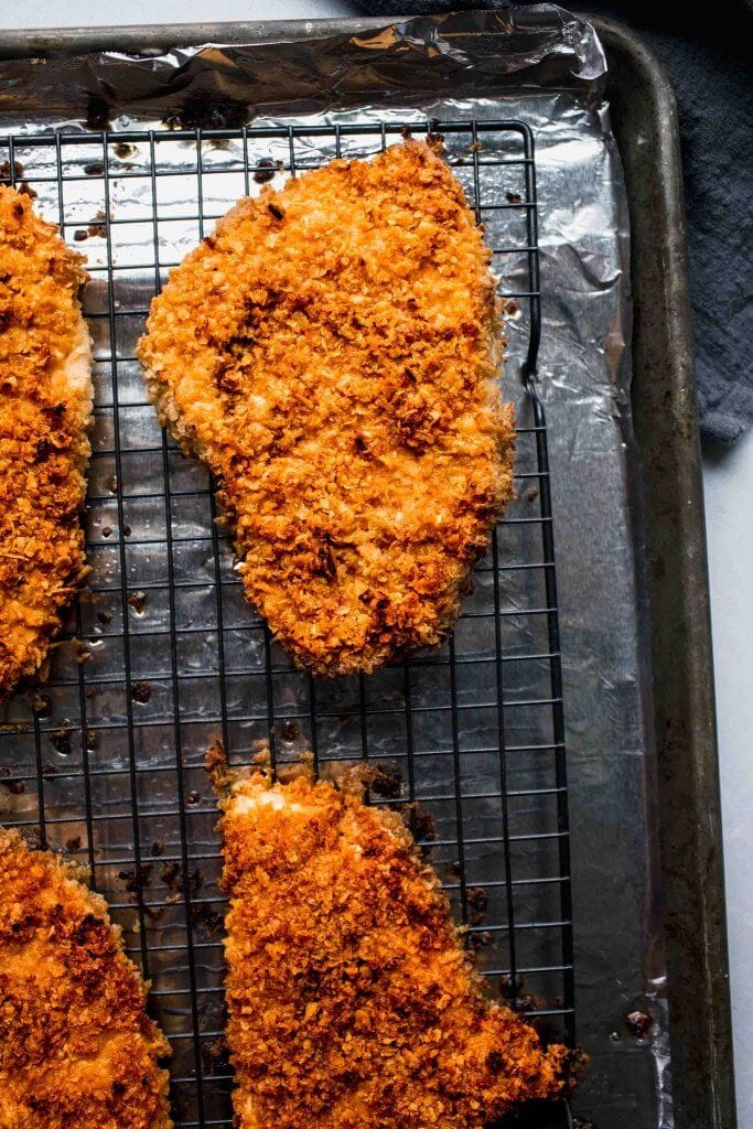 Crispy baked chicken on baking sheet.