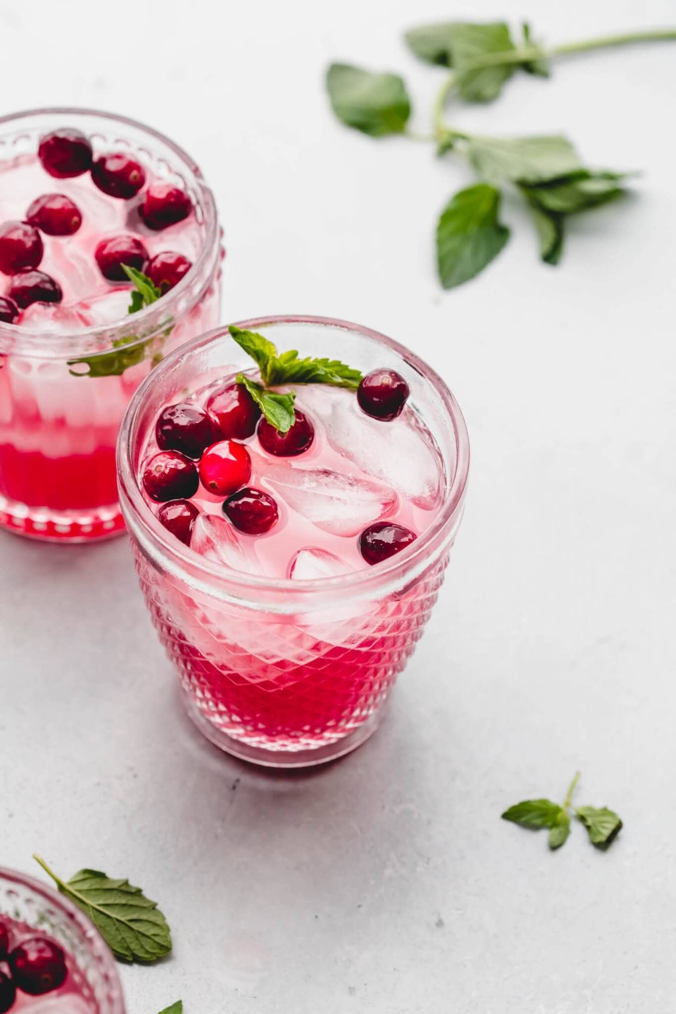 Two glasses of holiday punch with cranberries & mint. 