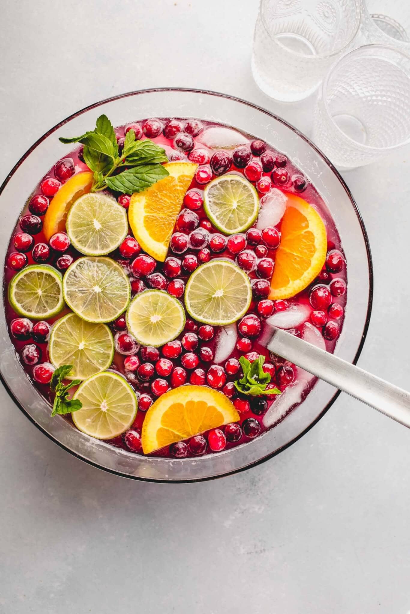 Christmas punch in bowl garnished with lime & orange slices, cranberries & mint sprigs.