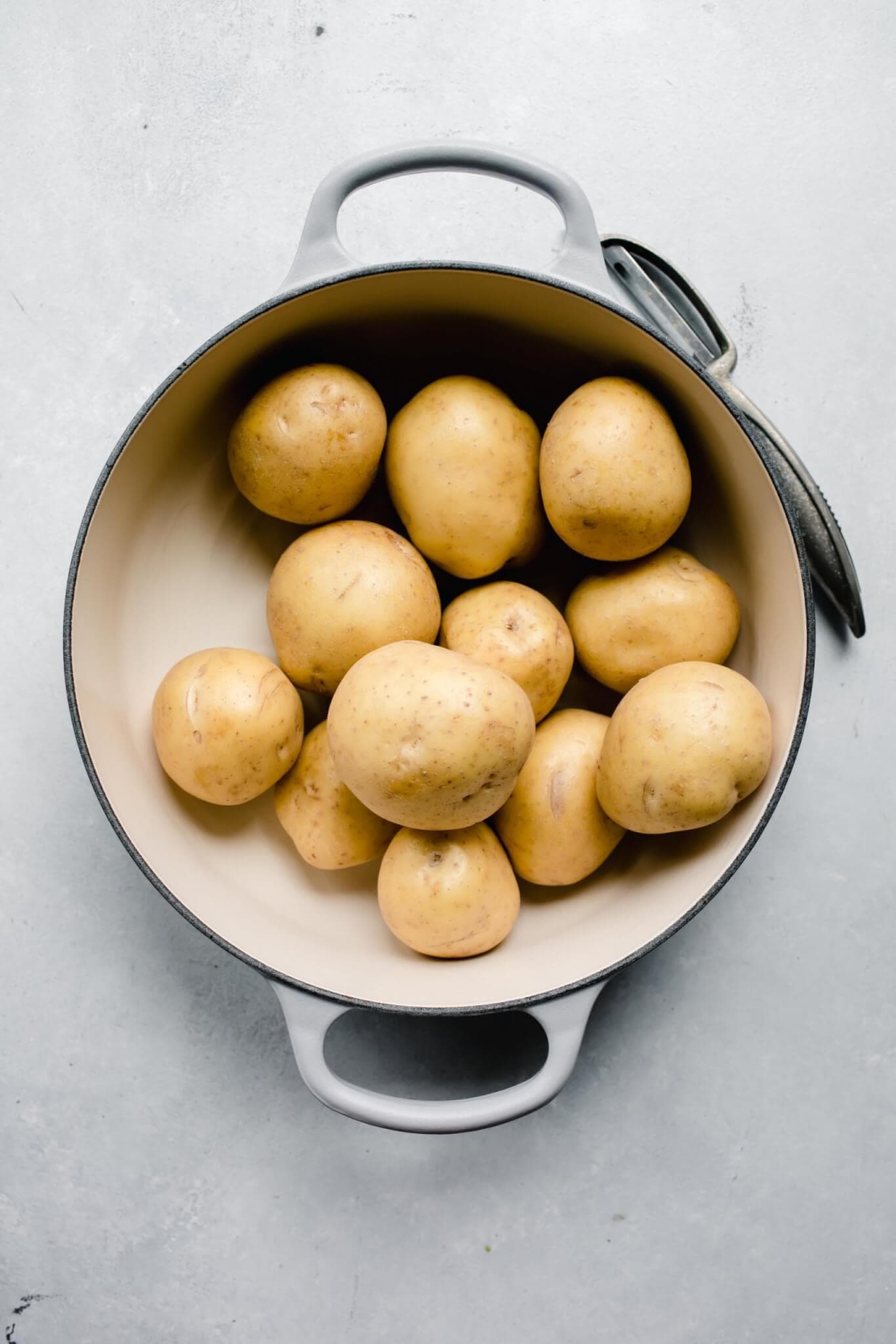 Uncooked, unpeeled potatoes in large dutch oven.