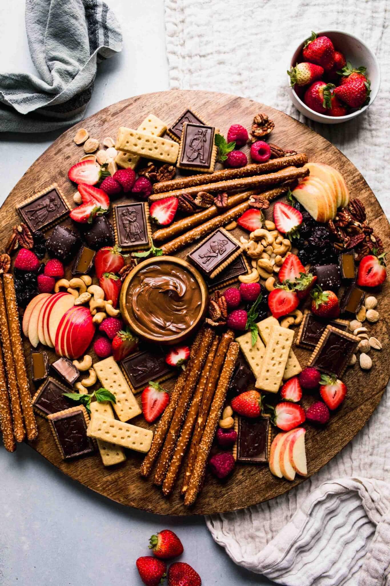 Dessert board arranged on wood round serving tray.