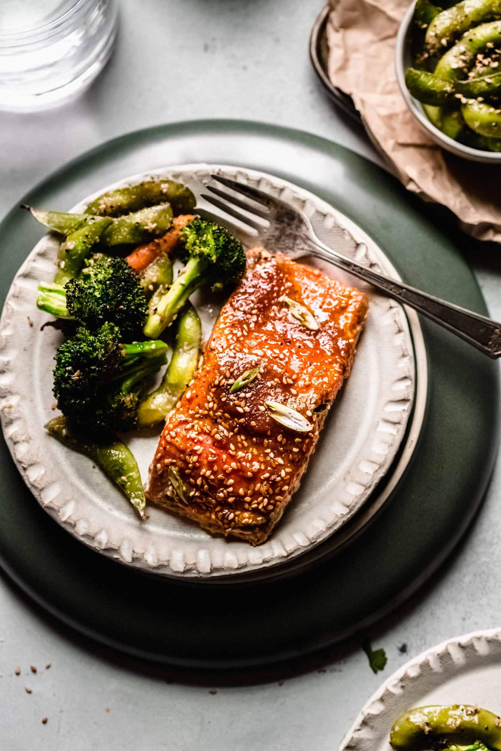 Miso salmon on small white plate with vegetables.