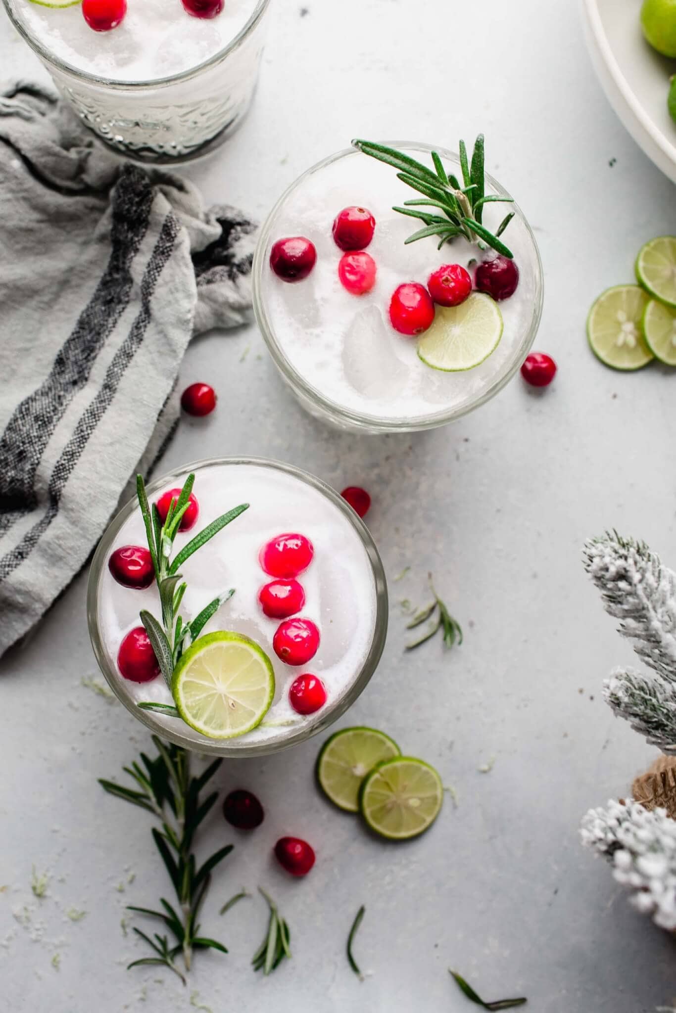 Overhead view of two White Christmas Margaritas garnished with cranberries and rosemary