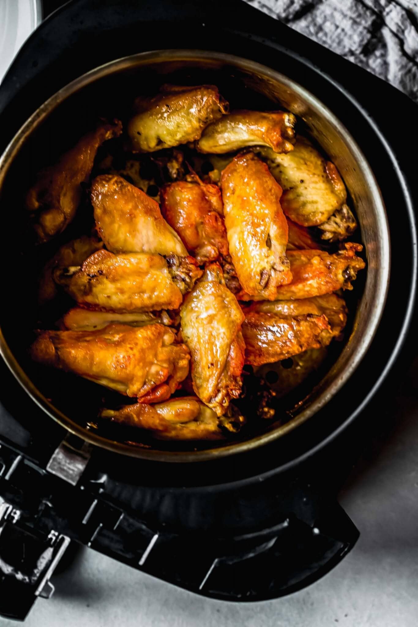 Wings in air fryer basket.