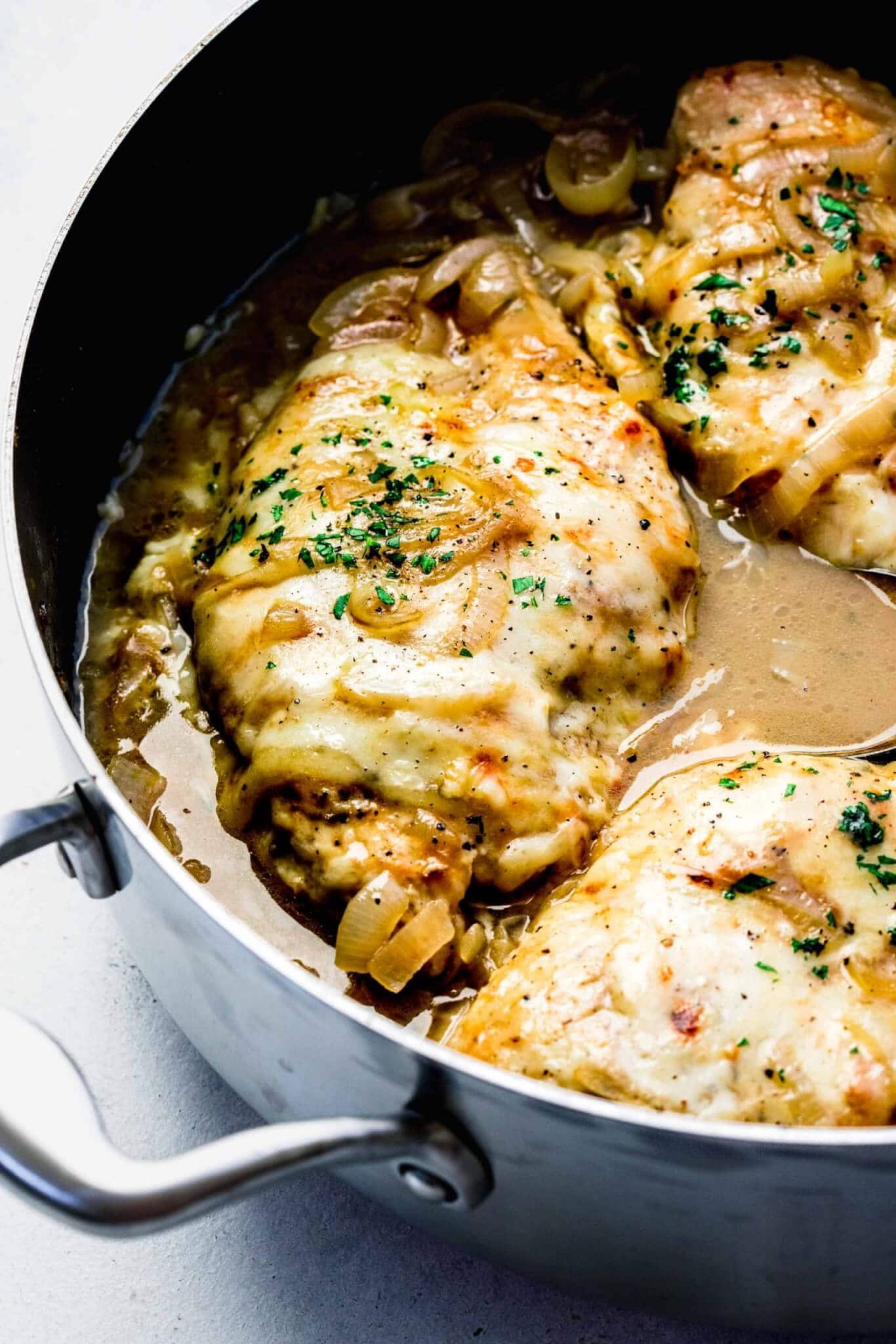 Close view of French Onion Chicken covered in melted cheese and parsley