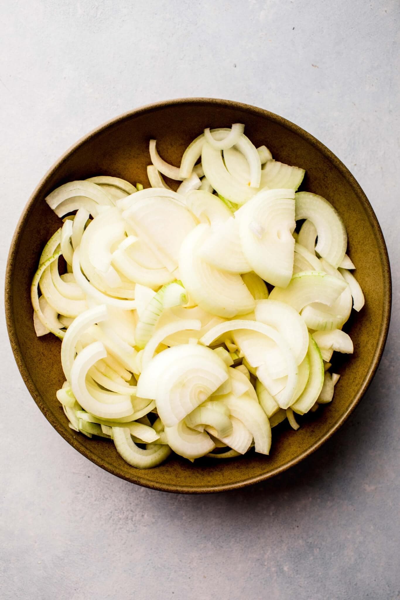 Raw onions sliced in bowl on counter