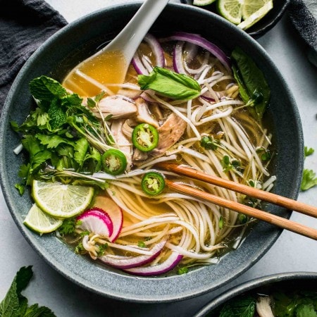 Overhead close up of bowl of pho with toppings.