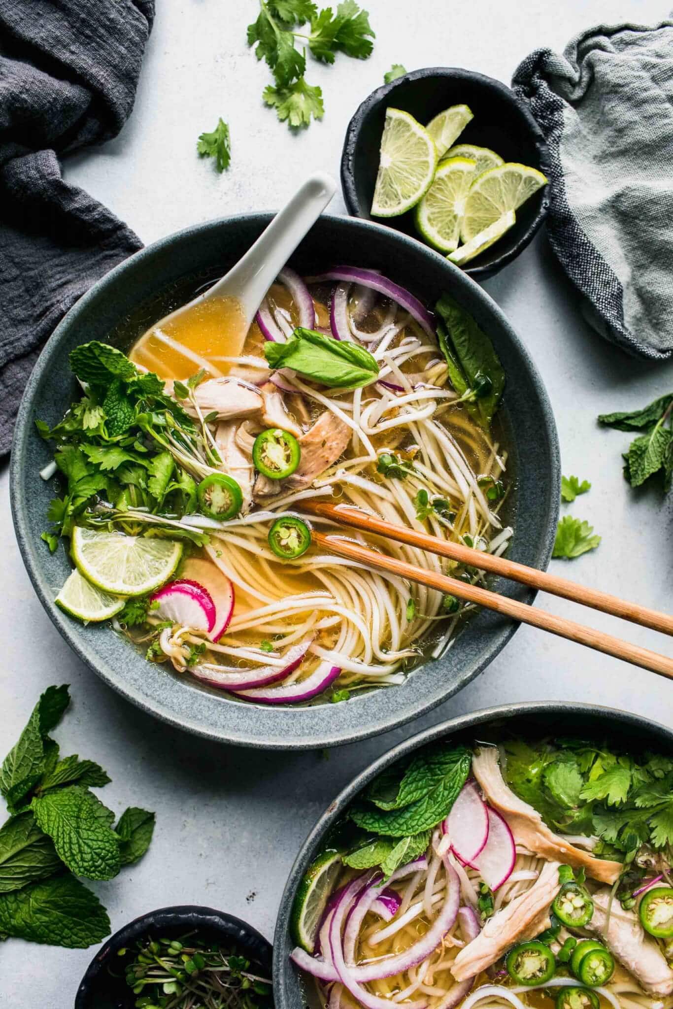 Two bowls of pho on counter