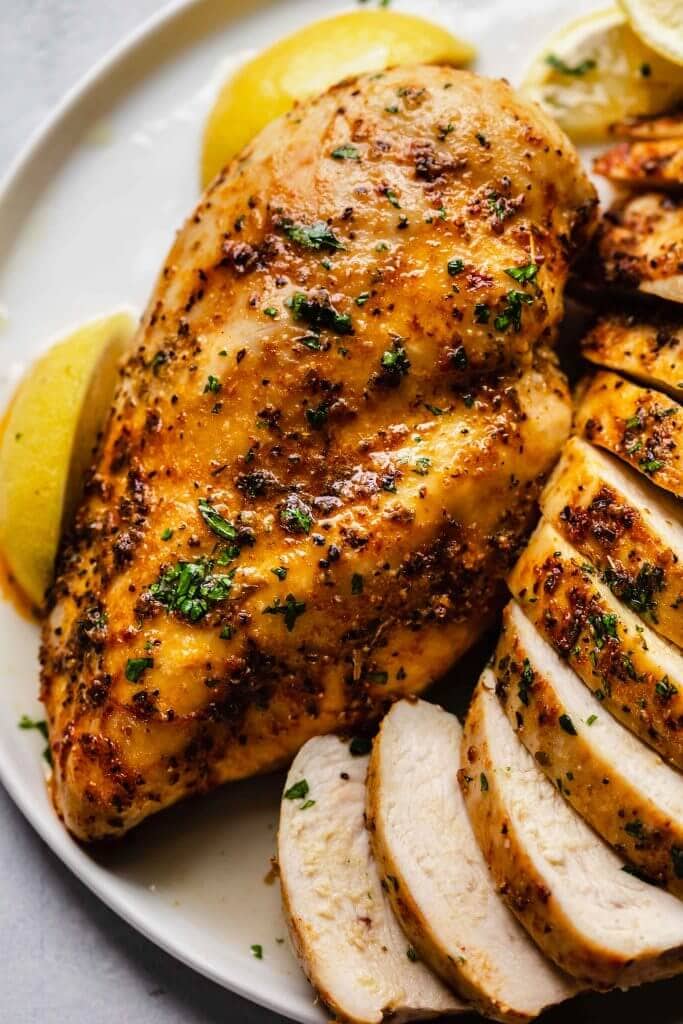 Overhead shot of juicy chicken breast on plate.