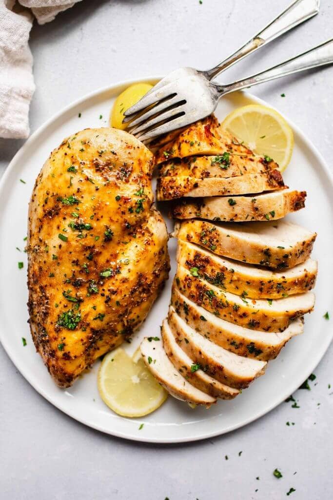 Plated chicken breasts with herbs and seasoning.