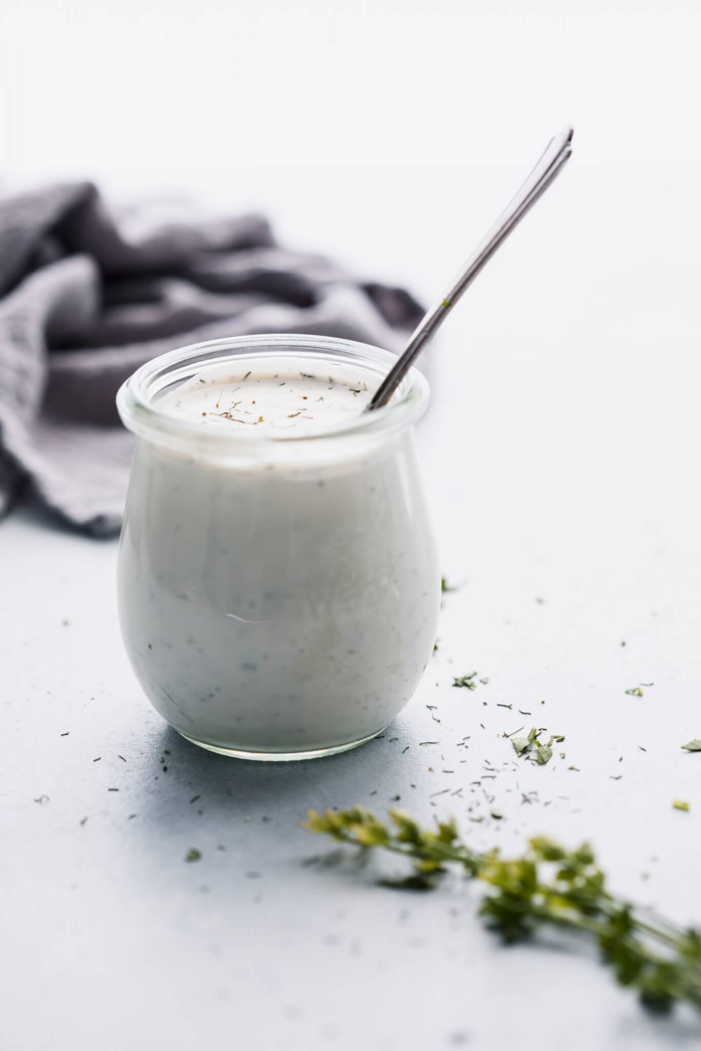 Side view of homemade ranch dressing in small jar. 