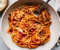 top shot of spaghetti noodles and tomato sauce in white bowl