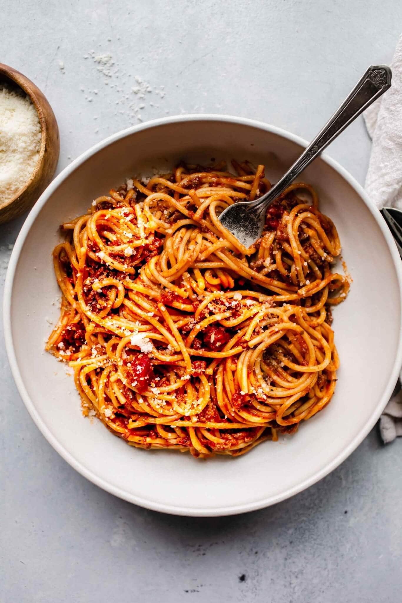 top shot of spaghetti noodles and tomato sauce in white bowl