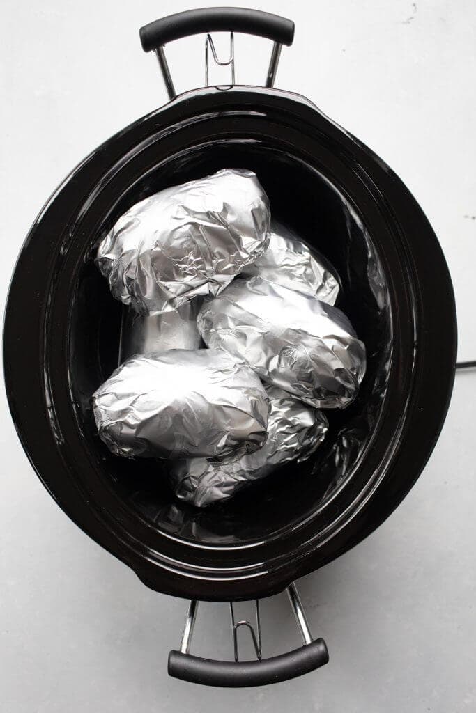 Potatoes wrapped in foil in slow cooker. 
