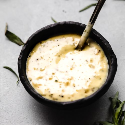 Bearnaise sauce in small black bowl.