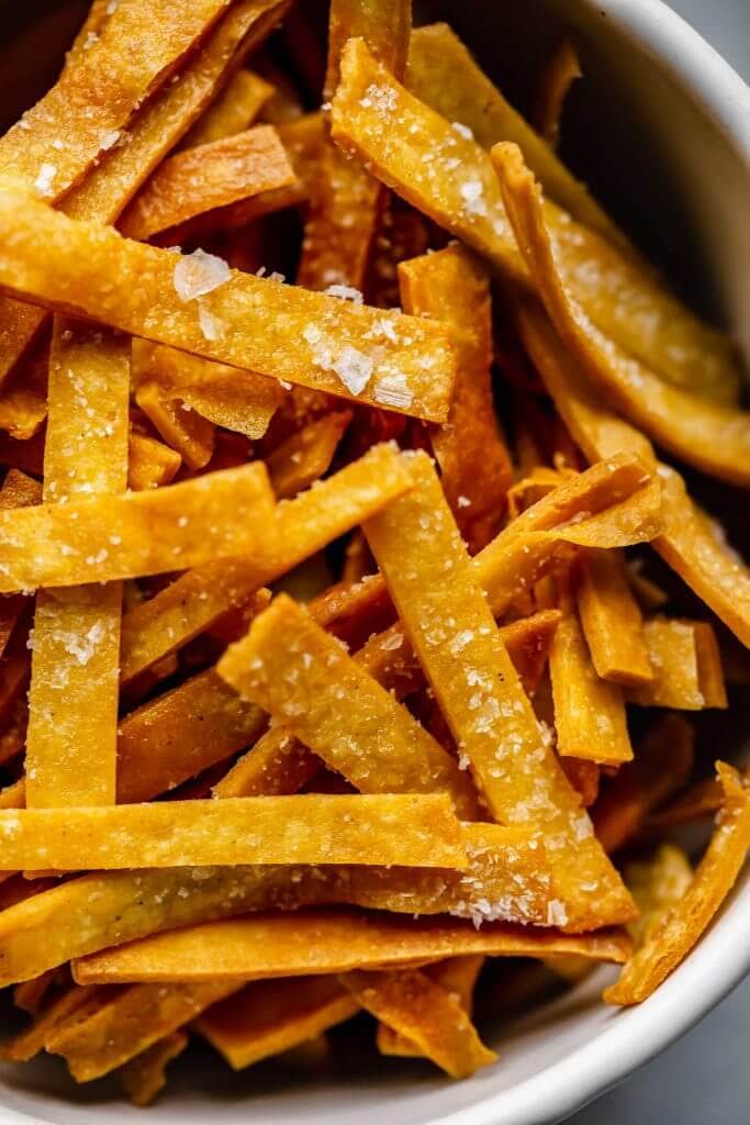 Close up of tortilla strips sprinkled with salt. 