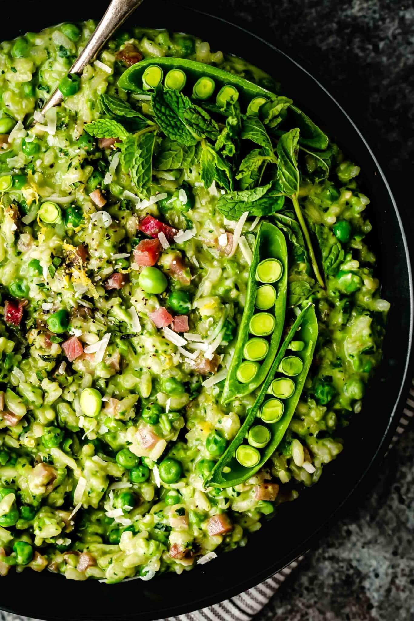 Overhead close up of bowl of risotto topped with peas.