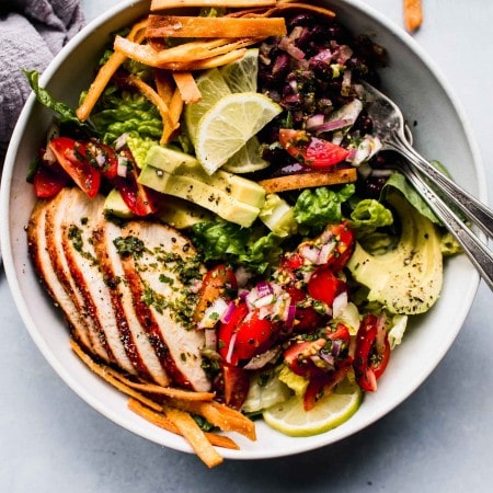 Overhead shot of sw chicken salad in bowl with two forks.