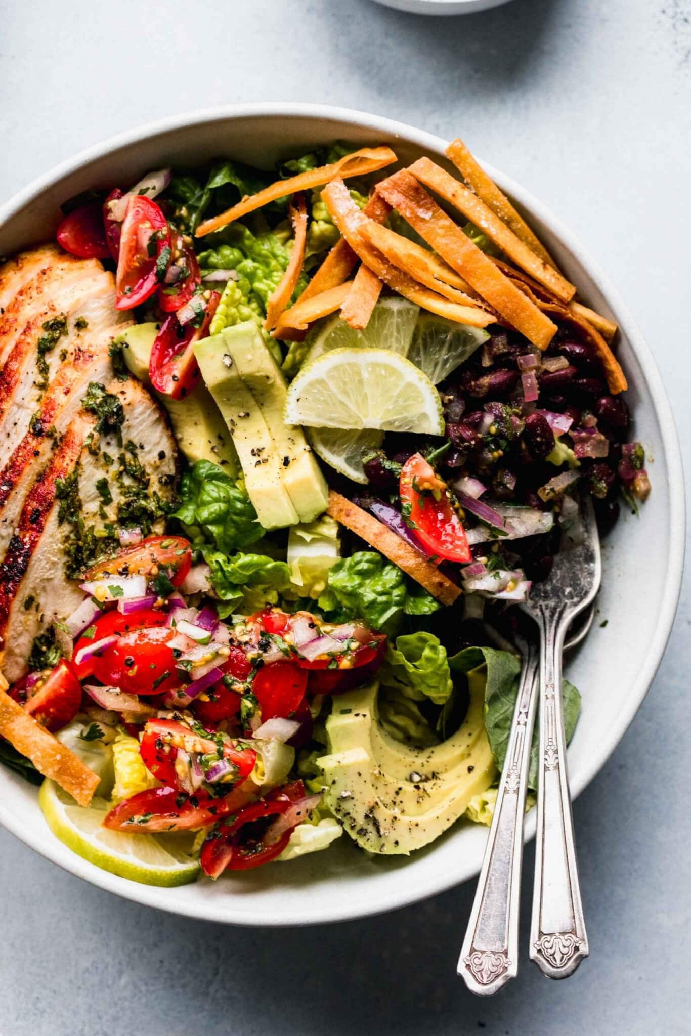 Overhead shot of sw chicken salad in bowl with two forks.